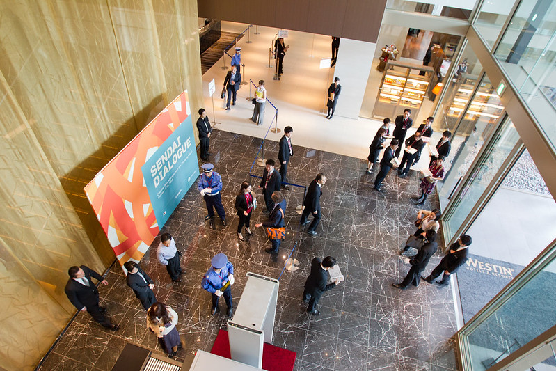 Delegates arriving at the venue entrance with event signage